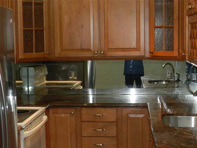 a kitchen with stainless steel appliances granite countertop a sink and cabinets