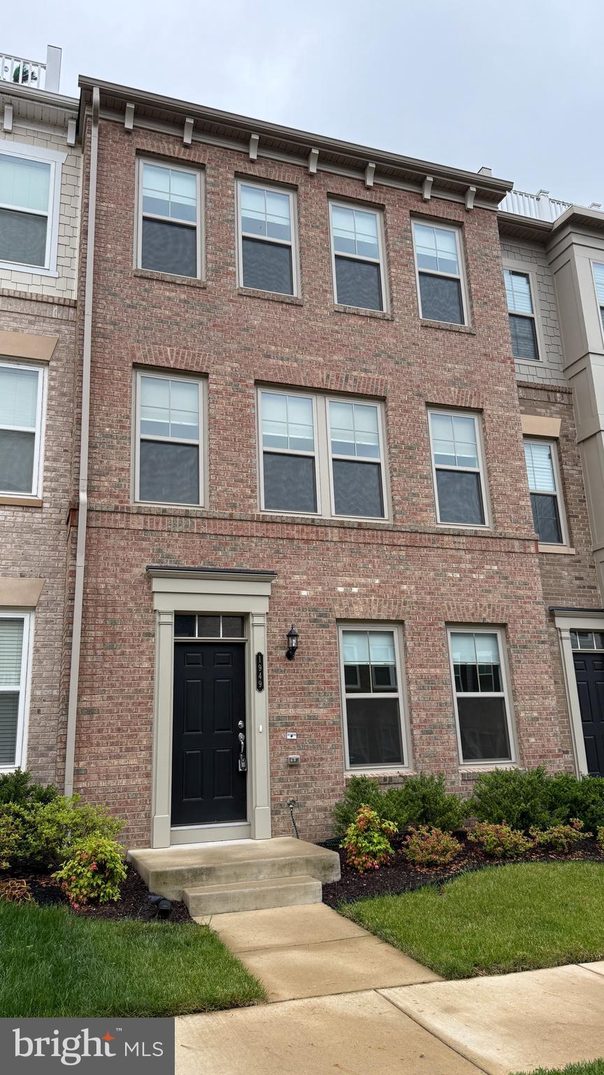 a front view of a brick house with a yard