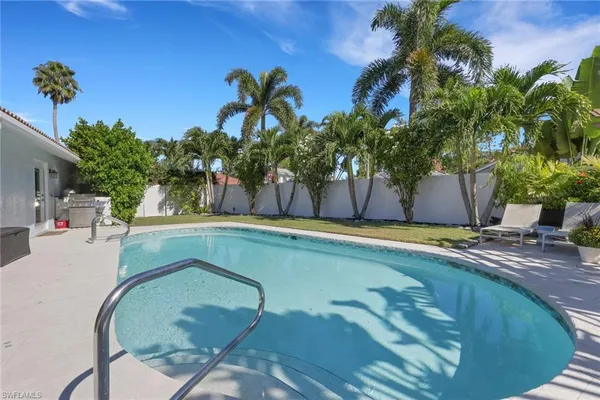 a swimming pool with outdoor seating and yard