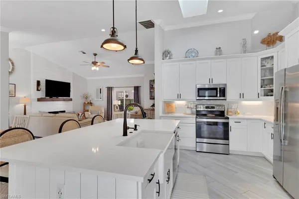 a kitchen with stainless steel appliances a stove a sink and a microwave