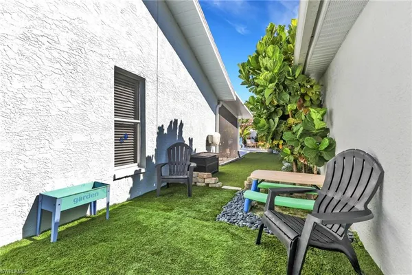 a view of a chair and table in backyard of the house