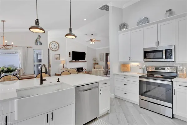 a kitchen with a sink a stove and white cabinets