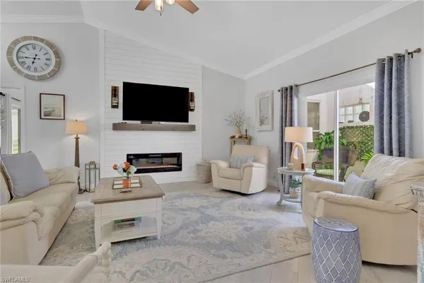 a living room with furniture a flat screen tv and a fireplace
