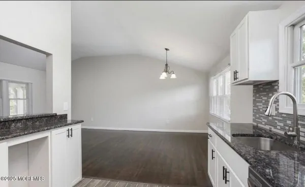 a kitchen with granite countertop stainless steel appliances a sink stove and cabinets