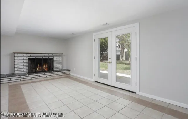 a view of an empty room with a fireplace and a window