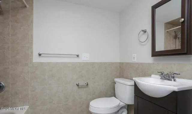 a bathroom with a sink vanity mirror and toilet