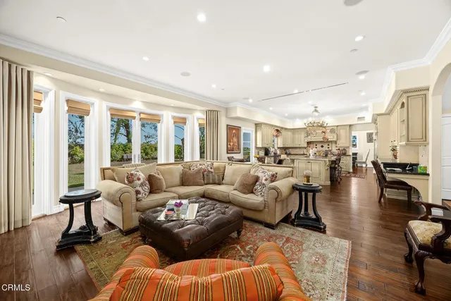 a living room with furniture a bookshelf and a chandelier