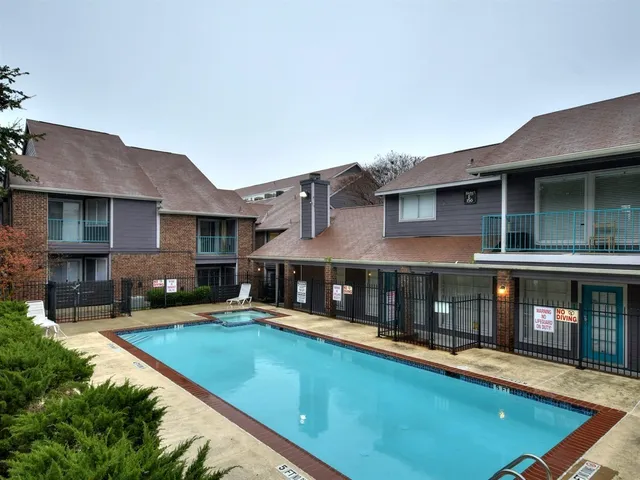 a view of a building with a swimming pool and sitting area