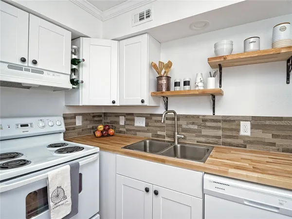 a kitchen with stainless steel appliances granite countertop a sink and a stove