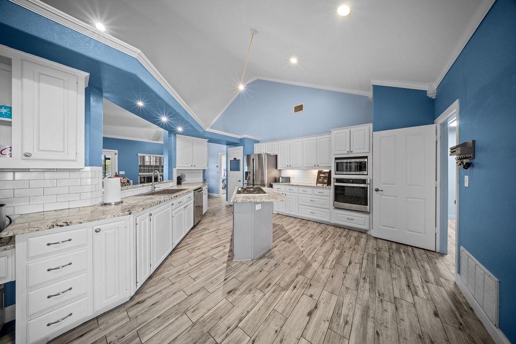 831 Union Hill Road Ennis, TX 75119 - Photo 12 of 38 a large kitchen with cabinets wooden floor and stainless steel appliances