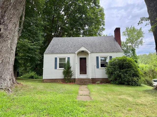 a front view of house with yard and trees