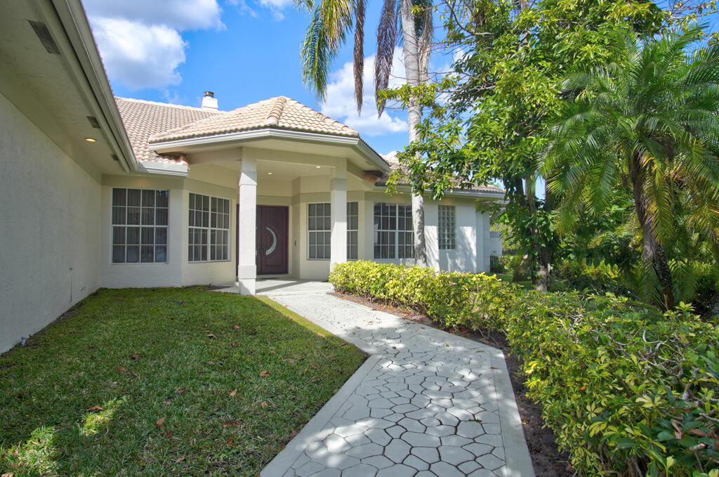 1823 Southwest 17th Street Boca Raton, FL 33486 - Photo 12 of 67 a view of a brick house with a large windows plants and large trees