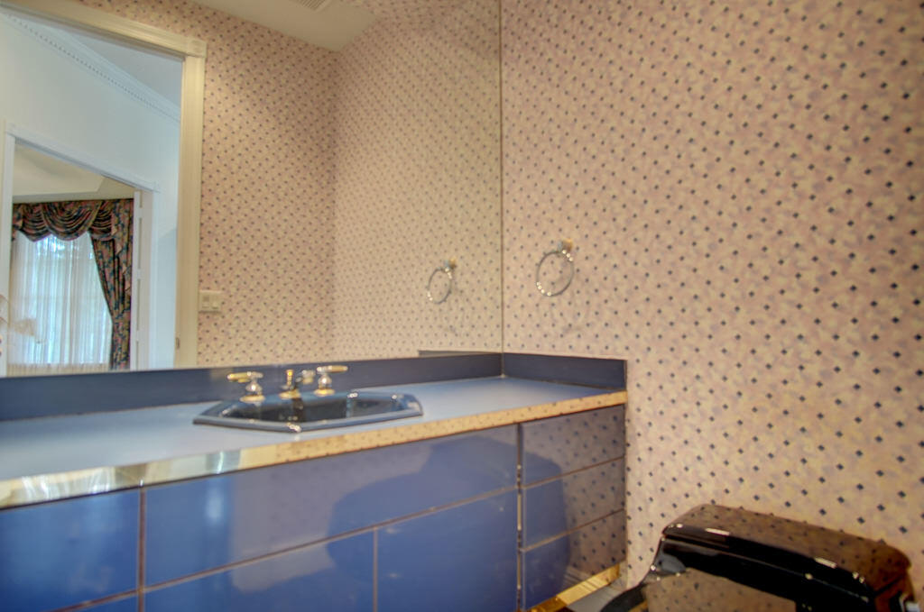 1823 Southwest 17th Street Boca Raton, FL 33486 - Photo 51 of 67 a bathroom with a granite countertop sink a mirror and shower