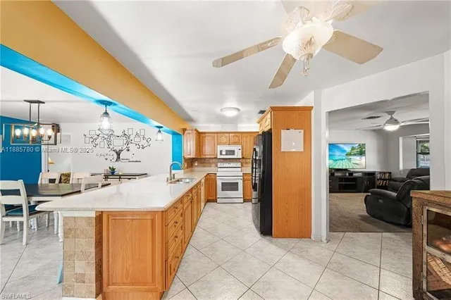 a large living room with stainless steel appliances kitchen island granite countertop furniture and a large window