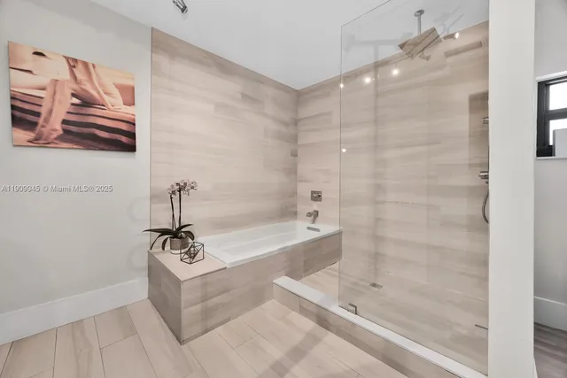 a bathroom with a tub a mirror and a shower