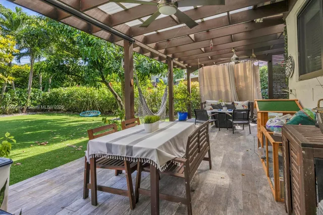 a view of a patio with table and chairs with wooden floor and fence