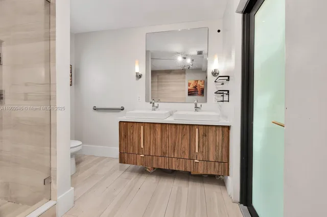 a bathroom with a sink a toilet and shower