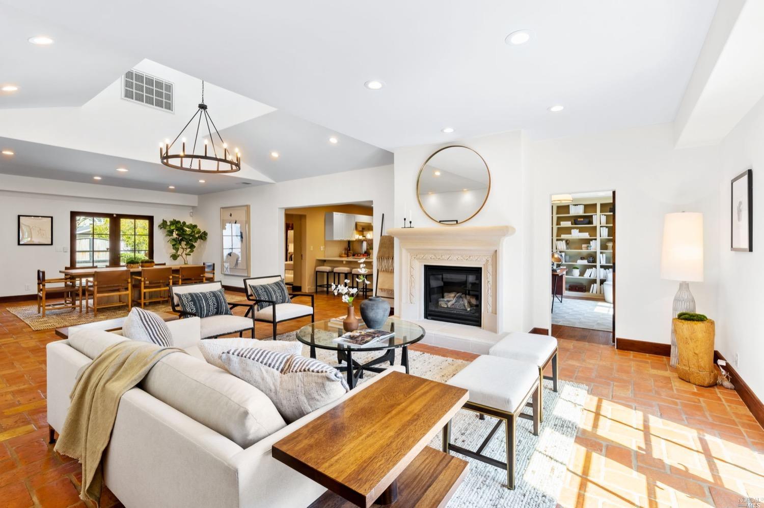 a living room with furniture a fireplace and a chandelier