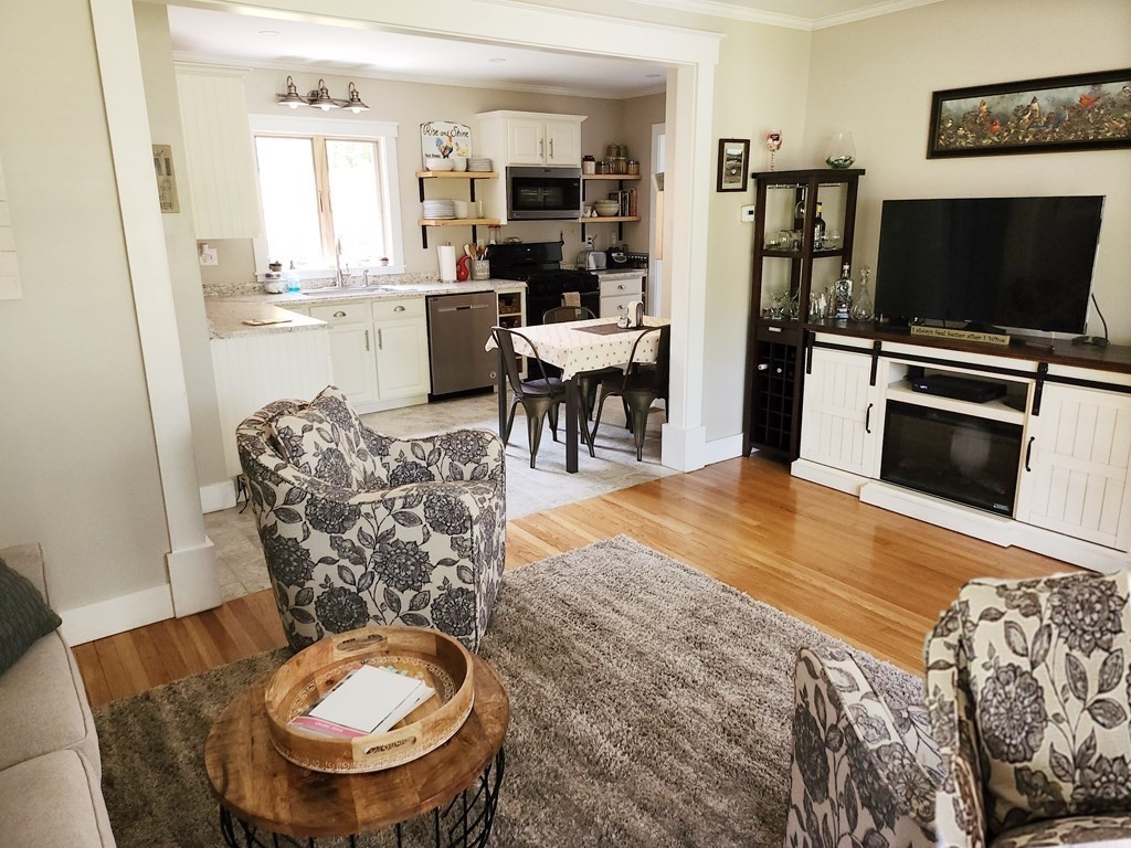 112 Marion Road Rochester, MA 02770 - Photo 4 of 18 a room with furniture a flat screen tv and kitchen view