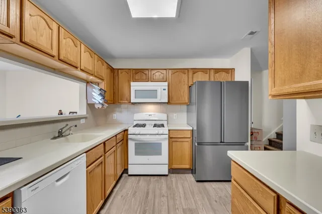 a kitchen with a sink a refrigerator a washer and dryer