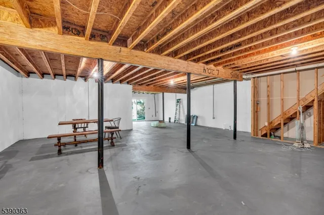a view of an empty room with wooden floor and furniture