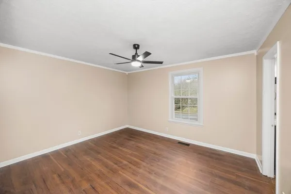 a view of a room with wooden floor and a ceiling fan