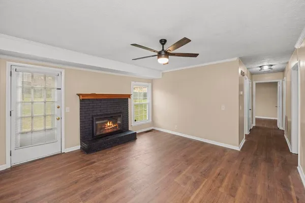 a view of an empty room with a fireplace and a window