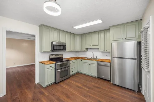 a kitchen with a refrigerator stove and wooden cabinets