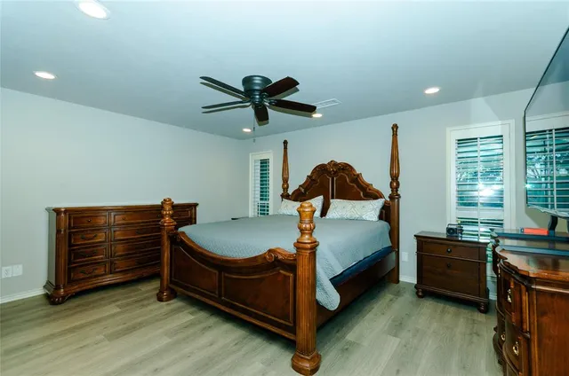 a bed room with a bed and a ceiling fan