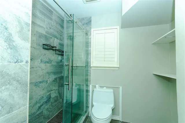 a bathroom with a toilet and shower