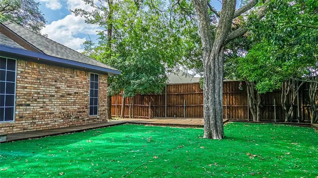 a view of a backyard with a large tree