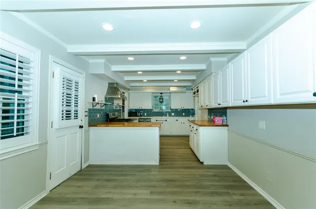 a kitchen with wooden floors and white walls