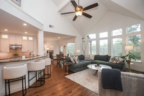 a living room with furniture wooden floor and a large window