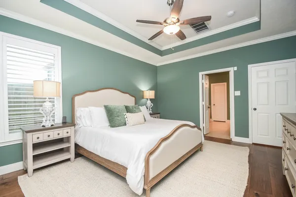 a bedroom with a bed chandelier and a window