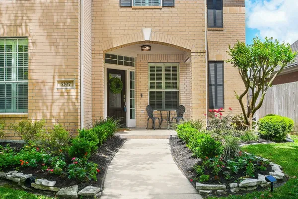 a front view of a house with a yard and potted plants