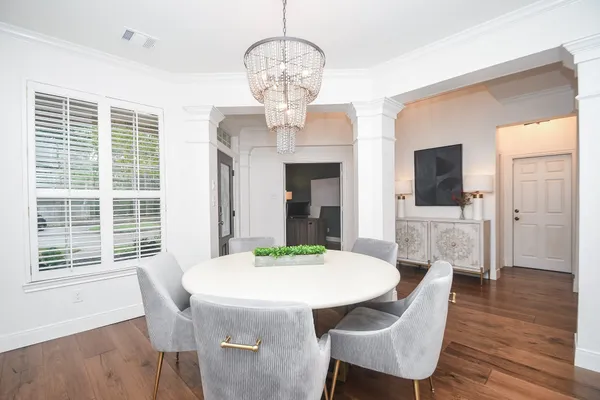 a view of a dining room with furniture a chandelier and wooden floor