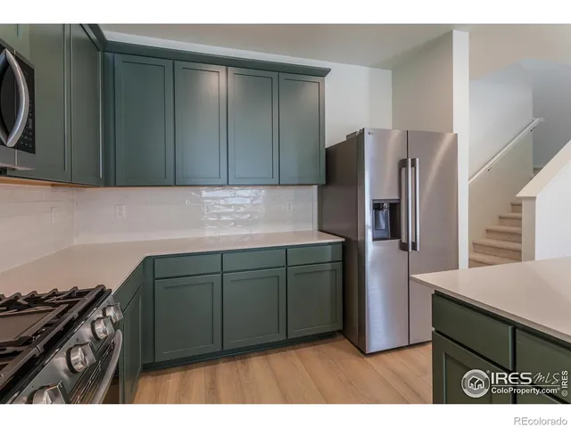 a kitchen with stainless steel appliances granite countertop a refrigerator and a stove