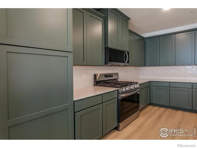 a kitchen with stainless steel appliances granite countertop a refrigerator a stove a sink and a microwave