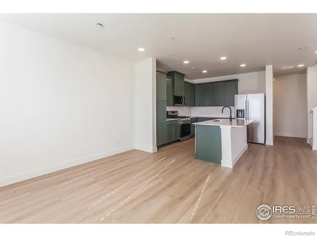 a open kitchen with stainless steel appliances granite countertop a stove top oven a sink and a refrigerator