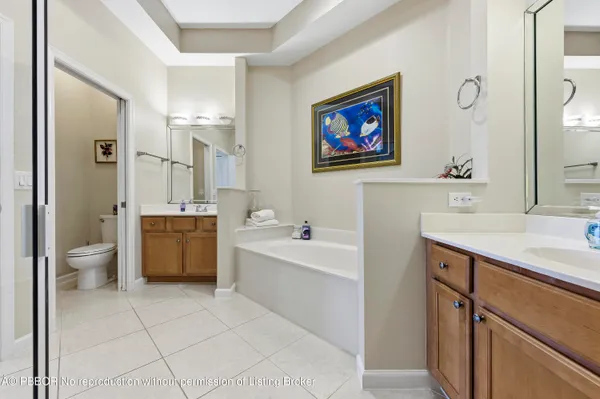 a spacious bathroom with a tub a sink and a mirror