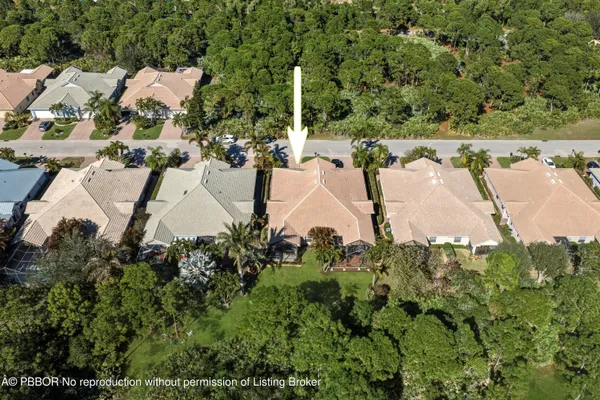 an aerial view of residential house with outdoor space and trees all around