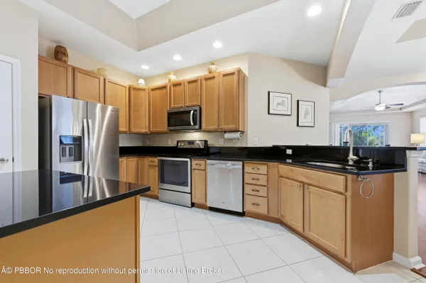 a large kitchen with stainless steel appliances a refrigerator a sink a stove a microwave a counter top and cabinets