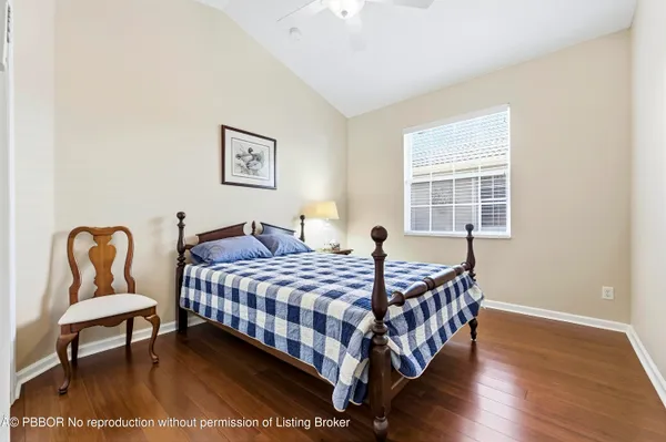 a bedroom with a bed a chair and painting on the wall