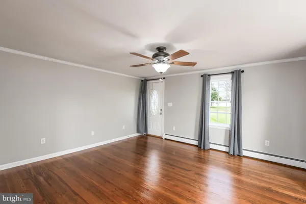 a view of an empty room with wooden floor