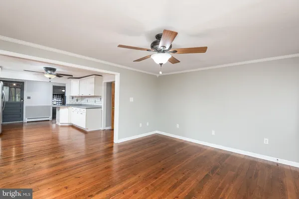 a view of a kitchen with a dishwasher a kitchen with wooden floor and a ceiling fan