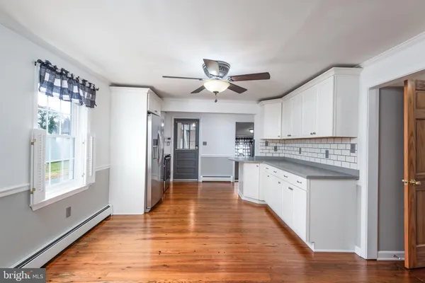 a large kitchen with granite countertop a large counter top space a sink stainless steel appliances and cabinets