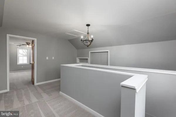 an empty room with windows and chandelier