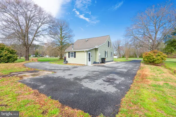 a front view of a house with a yard and trees