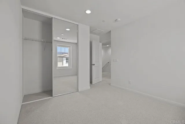 an empty room with windows and closet