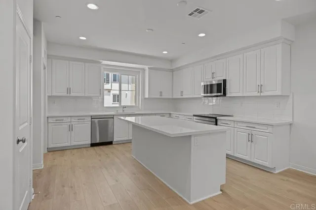 a kitchen with stainless steel appliances a sink stove and cabinets